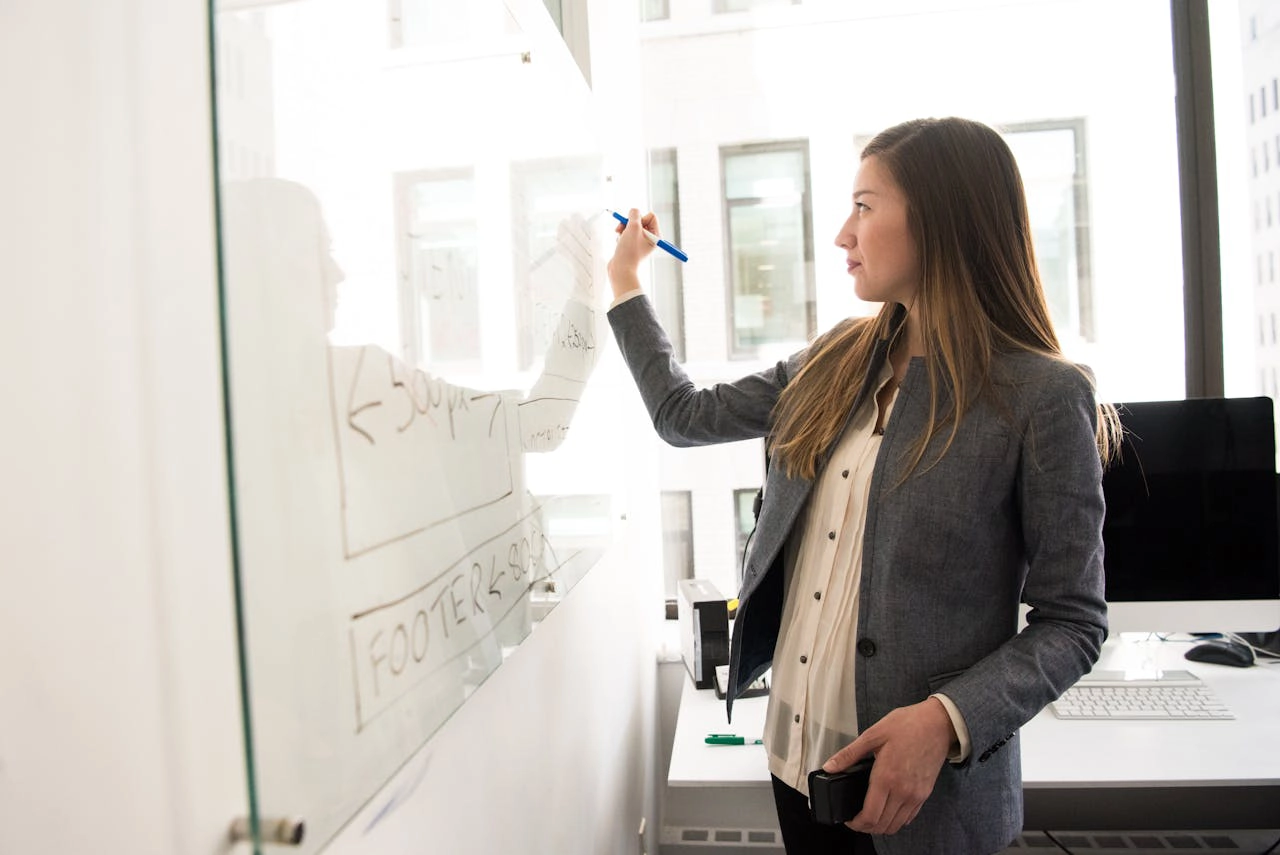 Photo of Woman Drawing on Whiteboard