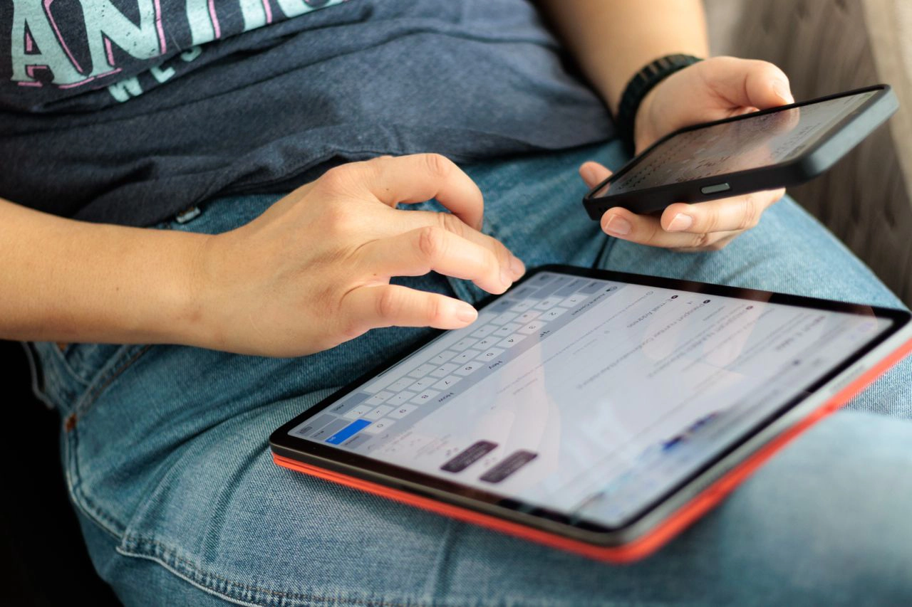 Photo of Person Using Tablet and Phone